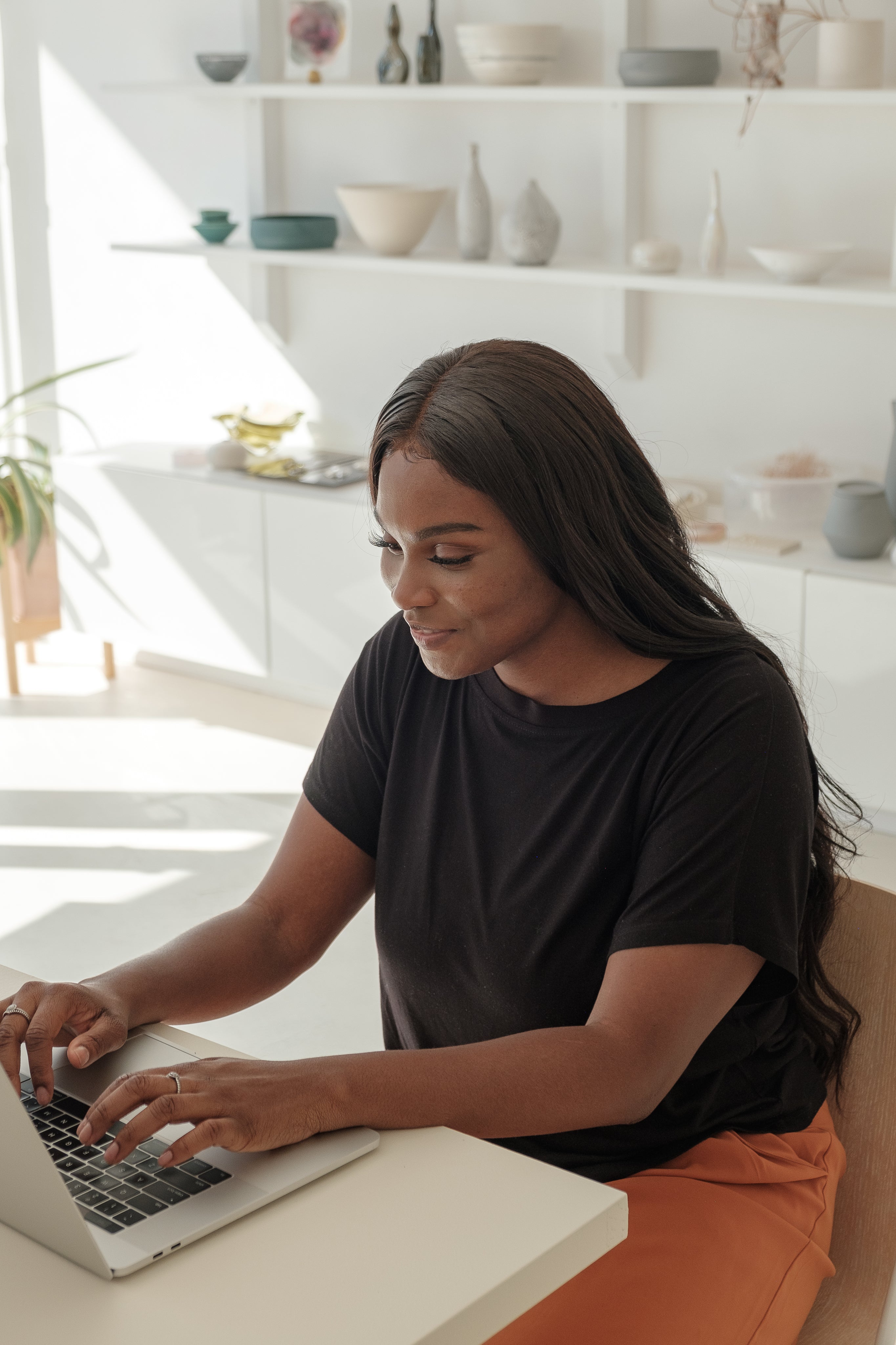 young-woman-smiles-as-she-checks-on-her-online-store.jpg